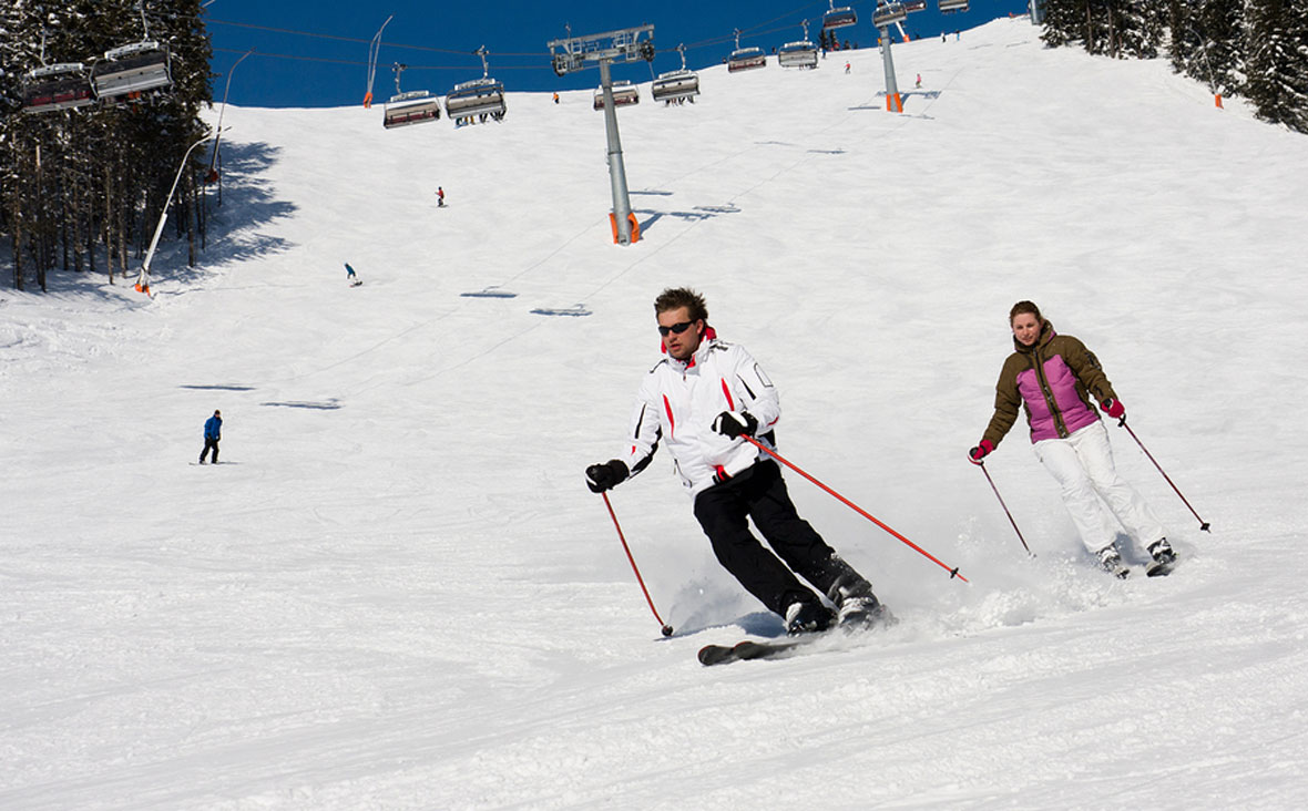 Man and woman downhill skiing